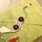 Cord closure detail on the green Ins Nepal Journal cover.