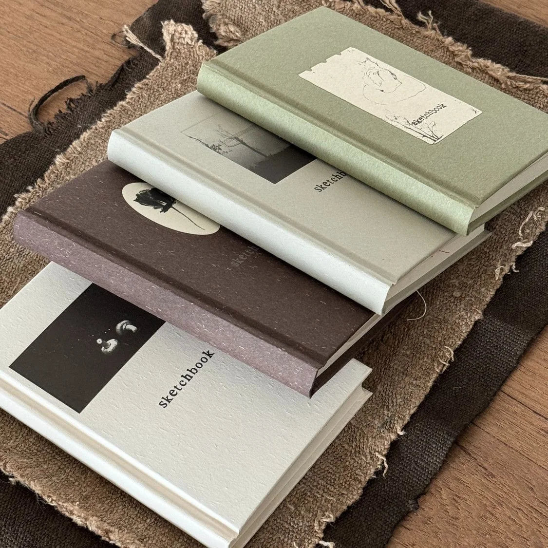 Minimal Sketch Pocket Journals stacked on a textured surface.