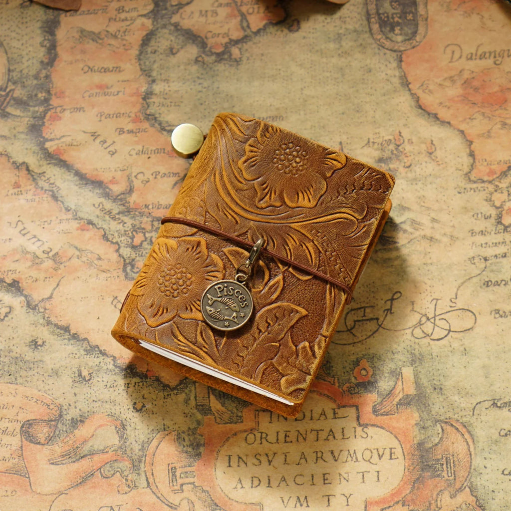 Pocket Traveler Wrap Journal in cognac on a warm textured surface.